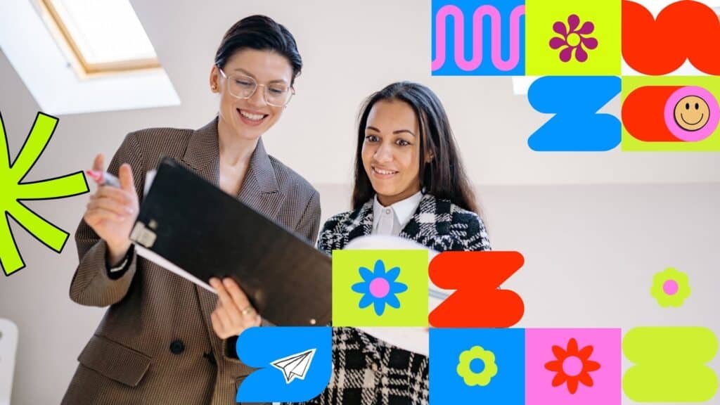 Two smiling businesswomen looking at documents in a folder together