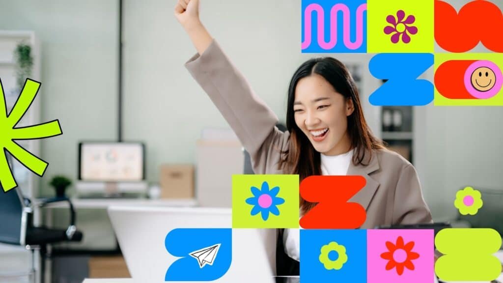 A smiling woman in an office celebrates with her fist raised.